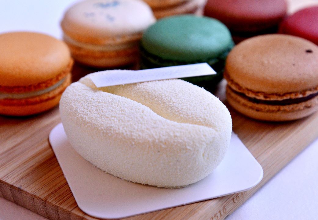Delicate Korean cake shaped like a grain of rice on a ceramic plate at a Seoul dessert cafe