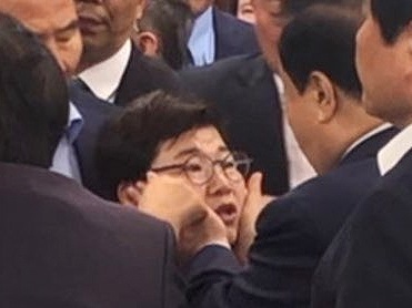 문희상 국회의장이 지난 24일 오전 여야 4당의 선거제·개혁법안 패스트트랙 문제로 국회의장실을 항의 방문한 자유한국당 의원 중 임이자 의원(가운데)의 얼굴을 양손으로 감싸고 있다. 자유한국당은 이날 문 의장이 동료의원을 성추행했다며 사퇴를 촉구하는 긴급 의원총회를 개최한다고 밝혔다. [연합]