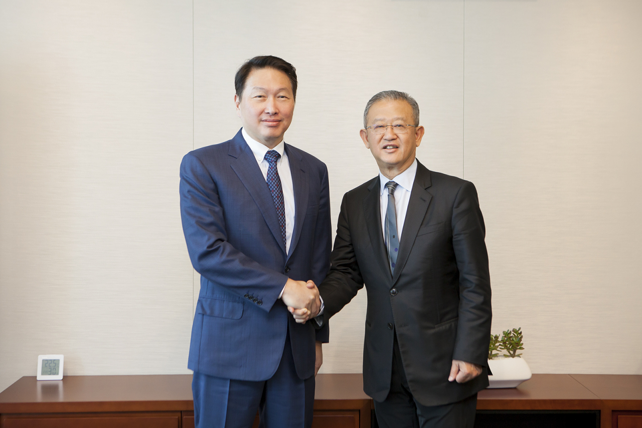 AIA Group CEO Ng Keng Hooi (right) and SK Group Chairman Chey Tae-won  shake hands during a meeting at the SK Telecom headquarters in Seoul, Thursday. (AIA Korea)
