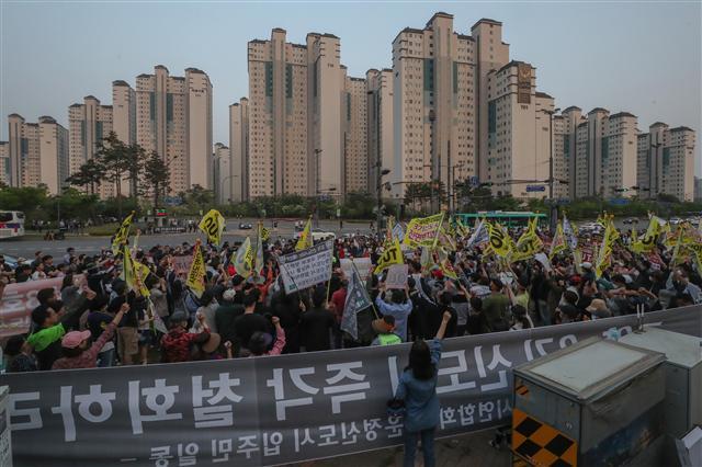 12일 경기도 파주시 운정행정복지센터 앞에서 고양 일산신도시 연합회와 파주 운정신도시 연합회, 인천 검단 신도시 연합회 주민들이 집회를 열고 3기 신도시 계획을 규탄하는 구호를 외치고 있다.   [연합]