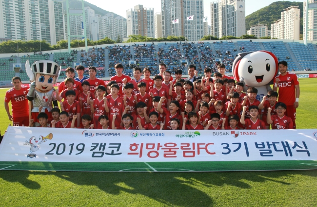 사진=한국자산관리공사(KAMCOㆍ캠코)는 12일 부산 구덕경기장에서 ‘캠코 희망울림 FC’ 어린이축구단 3기 6개 팀을 창단하고 발대식을 개최했다고 밝혔다. 참석자들이 부산아이파크 선수들과 함께 기념촬영을 하고 있다. [캠코 제공]