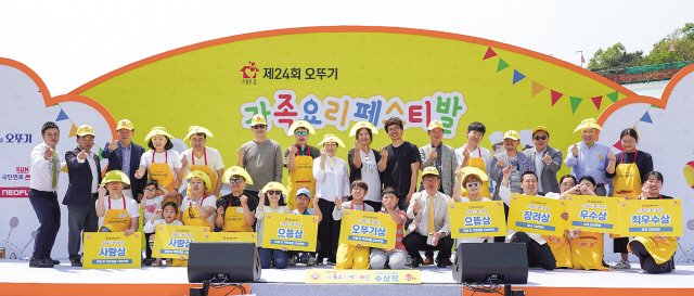 지난 11일 경기도 과천에 위치한 서울랜드 피크닉장에서 개최된 ‘제24회 오뚜기 가족요리 페스티발’ 행사장에서 수상 가족들이 행사 관계자들과 함께 기념사진을 촬영하고 있다. 이날 행사에는 가족 100팀과 요리전공 학생 50팀 총 150팀이 참가해 열띤 요리경연을 펼치는 한편, 오뚜기가 출연한 금액과 함께 참가비 전액을 선천성 심장병 어린이 지원을 위해 한국심장재단에 전달했다. 	 [오뚜기 제공]