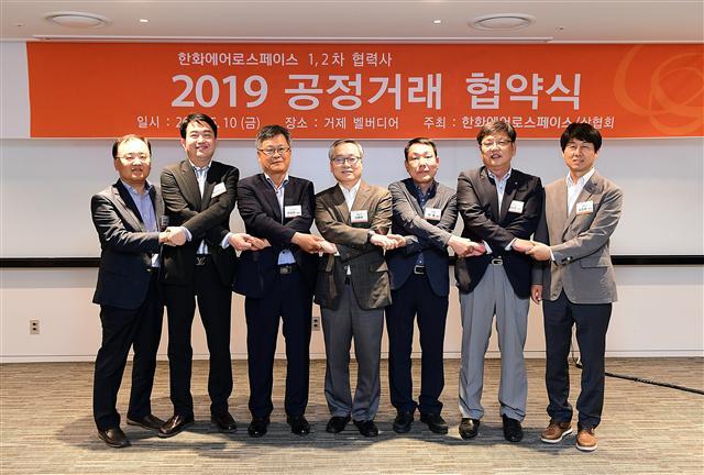 신현우 한화에어로스페이스 대표이사(가운데)와 주요 참석자들이 지난 10일 경남 거제의 벨버디어리조트에서 열린 2019년 ‘공정거래 협약식’에서 손을 맞잡고 동반성장과 상생협력의 의지를 다졌다.  [한화에어로스페이스 제공]