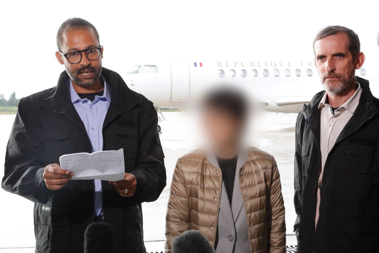 Korean woman (center) and French nationals rescued from militants speak to the media at a French military airbase on Saturday. Yonhap