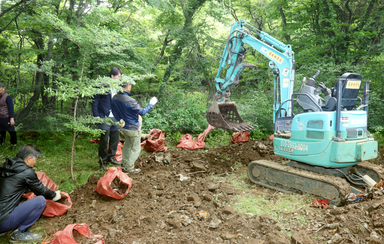 Fork lift removes garbage dump in Hallasan National Park in Jeju Island on May 16. (Yonhap)