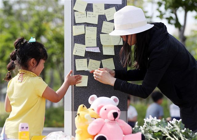 <YONHAP PHOTO-5196> '친구들아 하늘에서 편히 쉬렴' (인천=연합뉴스) 윤태현 기자 = 16일 오후 인천시 연수구 송도동 한 아파트단지 사거리 인근 공원에서 한 주민과 자녀가 교통사고로 숨진 어린이 2명을 추모하며 추모글을 적은 종이를 부착하고 있다. 2019.5.16 tomatoyoon@yna.co.kr/2019-05-16 17:08:58/ <저작권자 ⓒ 1980-2019 ㈜연합뉴스. 무단 전재 재배포 금지.>