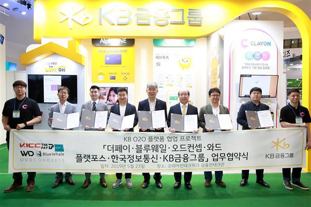 한동환(왼쪽 다섯번째) KB금융지주 디지털혁신총괄 전무가 지난 23일 서울 동대문디자인플라자에서 신영준 플랫포스 대표, 이원홍 블루웨일 대표, 용태순 와드 대표, 임명수 한국정보통신 대표, 조병찬 더페이 대표, 안진명 오드컨셉 이사 등과 협약을 맺은 뒤 기념촬영을 하고 있다.
[KB금융 제공]