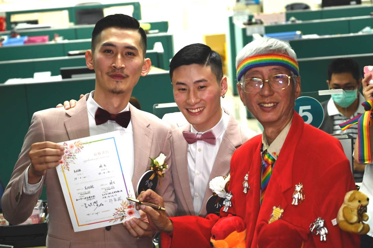 Taiwan's gay activist Chi Chia-Wei (right) signs a wedding certificate for gay couple Shane Lin and Marc Yuan (left) after registering at the Household Registration Office in Shinyi District in Taipei on May 24, 2019. (AFP=Yonhap)