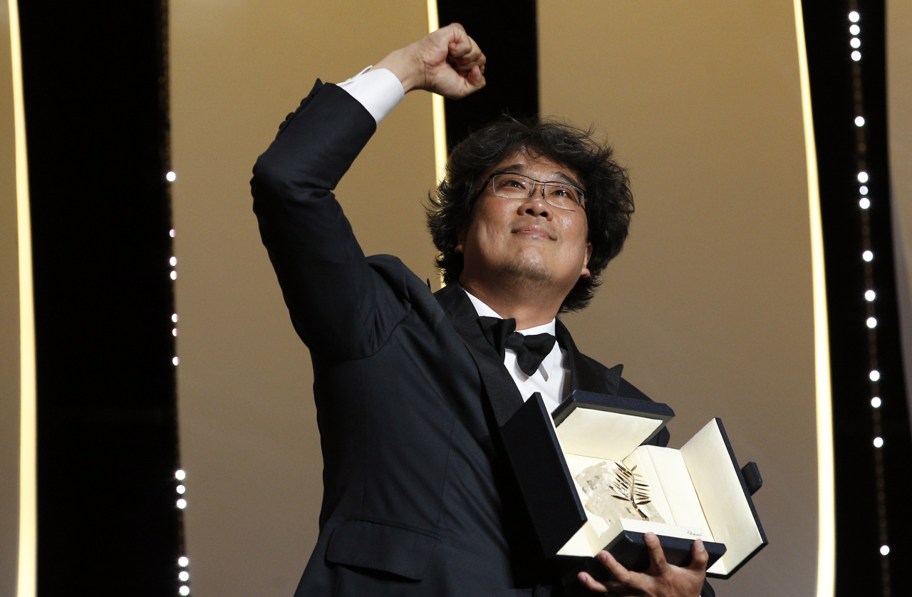 Director Bong Joon-ho holds the Palme d'Or trophy on stage at the 72nd Cannes Film Festival closing ceremony on May 25 2019 after Parasite became the first South Korean film in the festival's 72-year history to win the top prize