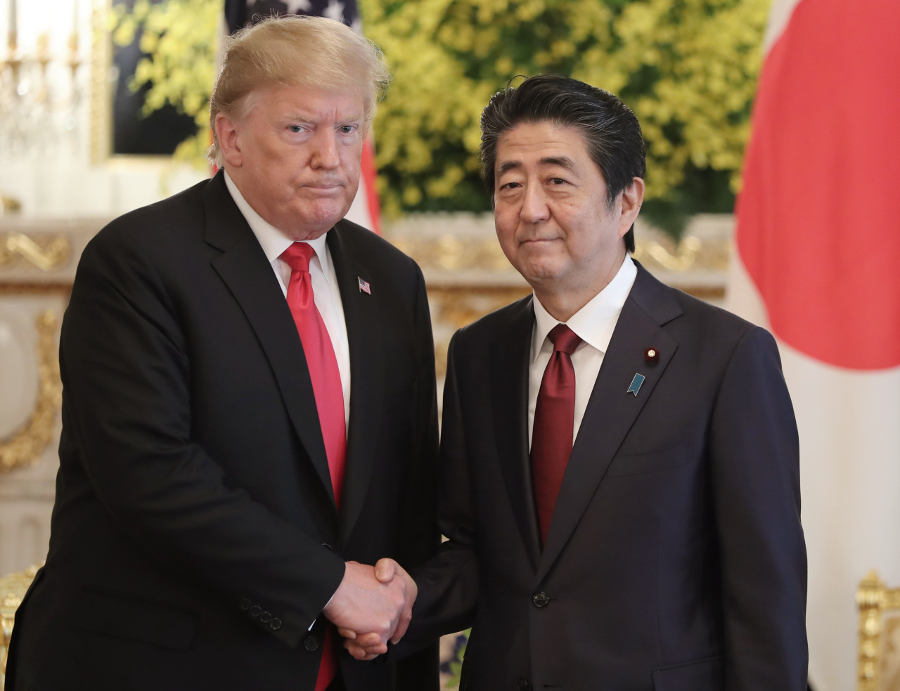US President Donald Trump and Japanese Prime Minister Shinzo Abe shake hands ahead of the summit meeting on Monday in Tokyo. Yonhap
