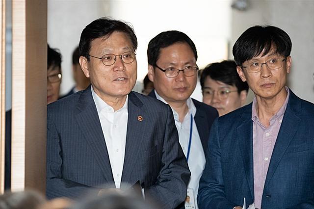 최종구 금융위원장이 지난 26일 인터넷전문은행 신규 예비인가 심사결과를 발표하기 위해 금융위 간부들과 서울 종로구 정부서울청사 합동브리핑실에 들어서고 있다.  [금융위 제공]