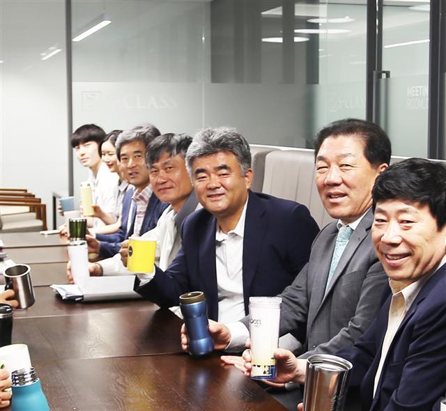 정원주 중흥건설그룹 사장<오른쪽 세번째>이 임직원들과 머그컵을 사용해 음료를 마시며 회의를 하고 있다.