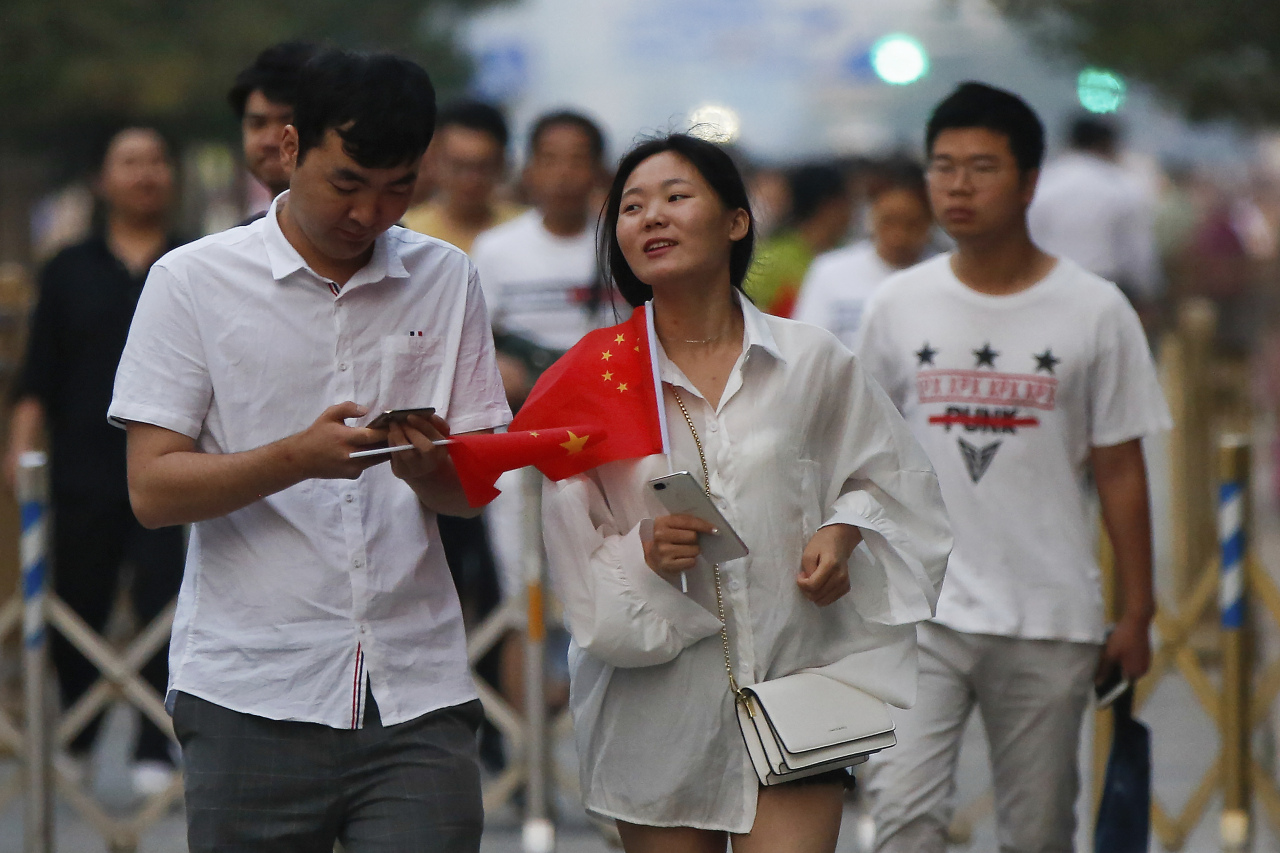 <YONHAP PHOTO-1290> A Chinese couple hold Chinese national flags after attending the daily flag raising ceremony at Tiananmen Square on the 30th anniversary for the 1989 crackdown on pro-democracy protest in Beijing, Tuesday, June 4, 2019. Critics say the Tiananmen crackdown, which left hundreds, possibly thousands, dead, set the ruling Communist Party on its present course of ruthless suppression, summary incarceration and the frequent use of violence against opponents in the name of "stability maintenance." (AP Photo/Andy Wong)/2019-06-04 07:44:49/ <저작권자 ⓒ 1980-2019 ㈜연합뉴스. 무단 전재 재배포 금지.>
<YONHAP PHOTO-1290> A Chinese couple hold Chinese national flags after attending the daily flag raising ceremony at Tiananmen Square on the 30th anniversary for the 1989 crackdown on pro-democracy protest in Beijing, Tuesday, June 4, 2019. Critics say the Tiananmen crackdown, which left hundreds, possibly thousands, dead, set the ruling Communist Party on its present course of ruthless suppression, summary incarceration and the frequent use of violence against opponents in the name of "stability maintenance." (AP Photo/Andy Wong)/2019-06-04 07:44:49/ <저작권자 ⓒ 1980-2019 ㈜연합뉴스. 무단 전재 재배포 금지.>