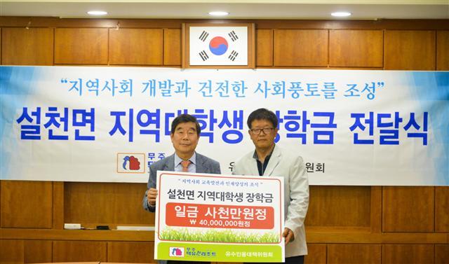 부영그룹 무주덕유산리조트 김시권 대표이사(왼쪽)가 지난달 31일 백남운 유수인용대책위원회 위원장에게 저소득가구 대학생 장학금을 전달하고 기념사진을 찍고 있다 . [부영그룹 제공]