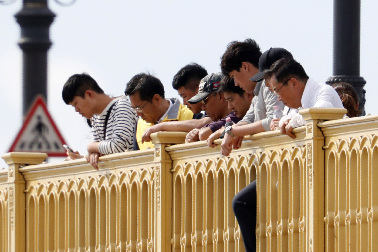 Family members of missing South Korean tourists watch the ongoing search operation from the Margaret Bridge over the Danube river where a sightseeing boat capsized in Budapest, Hungary, Monday, June 3, 2019. Preparations for salvage efforts of a sunken tour boat in the Danube River have resumed in Budapest. The boat carrying South Korean tourists capsized and sank Wednesday night after colliding with a much larger river cruise ship near the Hungarian Parliament building. (AP Photo/Laszlo Balogh)