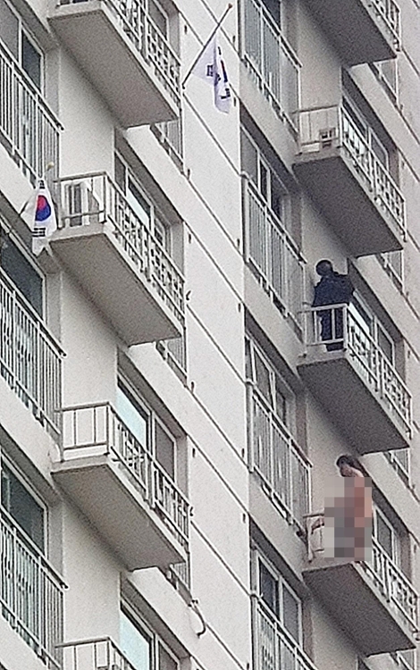 A man, 51, stands naked on the 12th-floor balcony of an apartment building in Uijeongbu, Gyeonggi Province, at around 7 a.m. Thursday. (Yonhap)