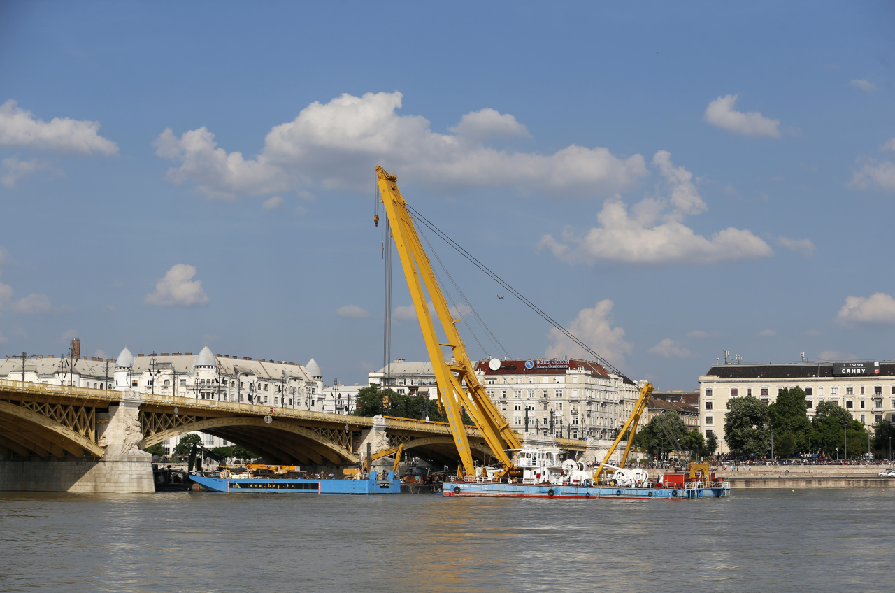 A crane float on the Danube river under the Margaret Bridge where a sightseeing boat capsized in Budapest, Hungary, Monday, June 10, 2019. A huge floating crane is in place at Margit Bridge as preparations continue to lift the boat off the river floor. (AP-Yonhap)