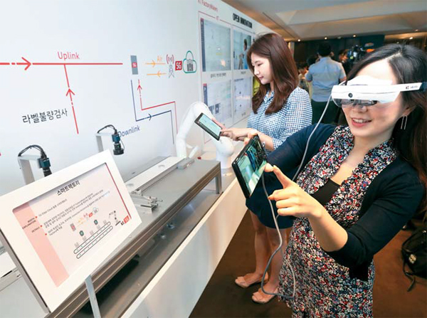 Visitors try out AR devices for KT's 5G-powered smart factory. KT