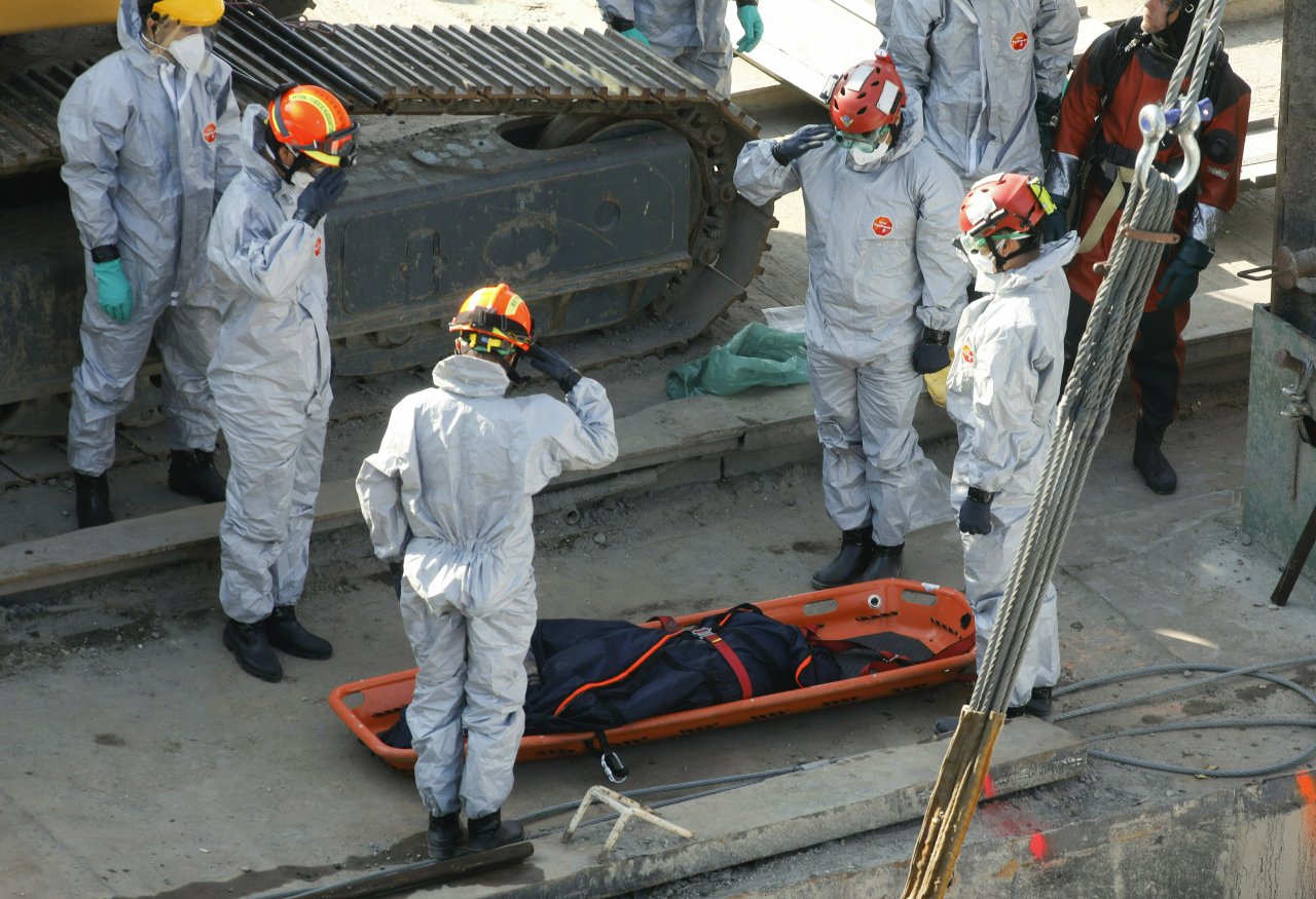 Rescue team members salute next to a recently found victim during the recovery operation at Margaret Bridge, the scene of the fatal boat accident in Budapest, Hungary, Tuesday, June 11, 2019. (AP-Yonhap)