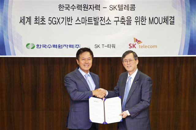 박정호 SK텔레콤 사장(왼쪽)이 정재훈 한국수력원자력 사장과 스마트발전소 협약을 맺고 기념촬영을 하고 있다.  [SK텔레콤 제공]
