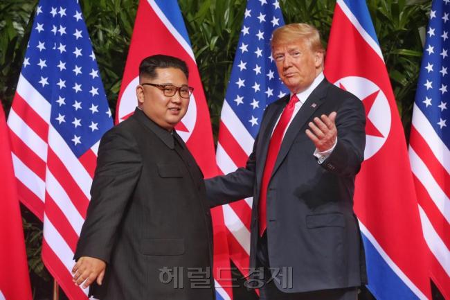 미국 행정부는 북한 비핵화 해법으로 일괄타결식 빅딜 입장을 유지하고 있지만 미 전직관료들 사이에서는 단계적 비핵화 해법이 현실적이라는 의견이 우세한 것으로 나타났다. 김정은 북한 국무위원장과 도널드 트럼프 미국 대통령이 1년 전인 2018년 6월12일 싱가포르에서 처음 만나 악수를 나눈 뒤 기자들을 향해 자세를 취하고 있다. [헤럴드DB]