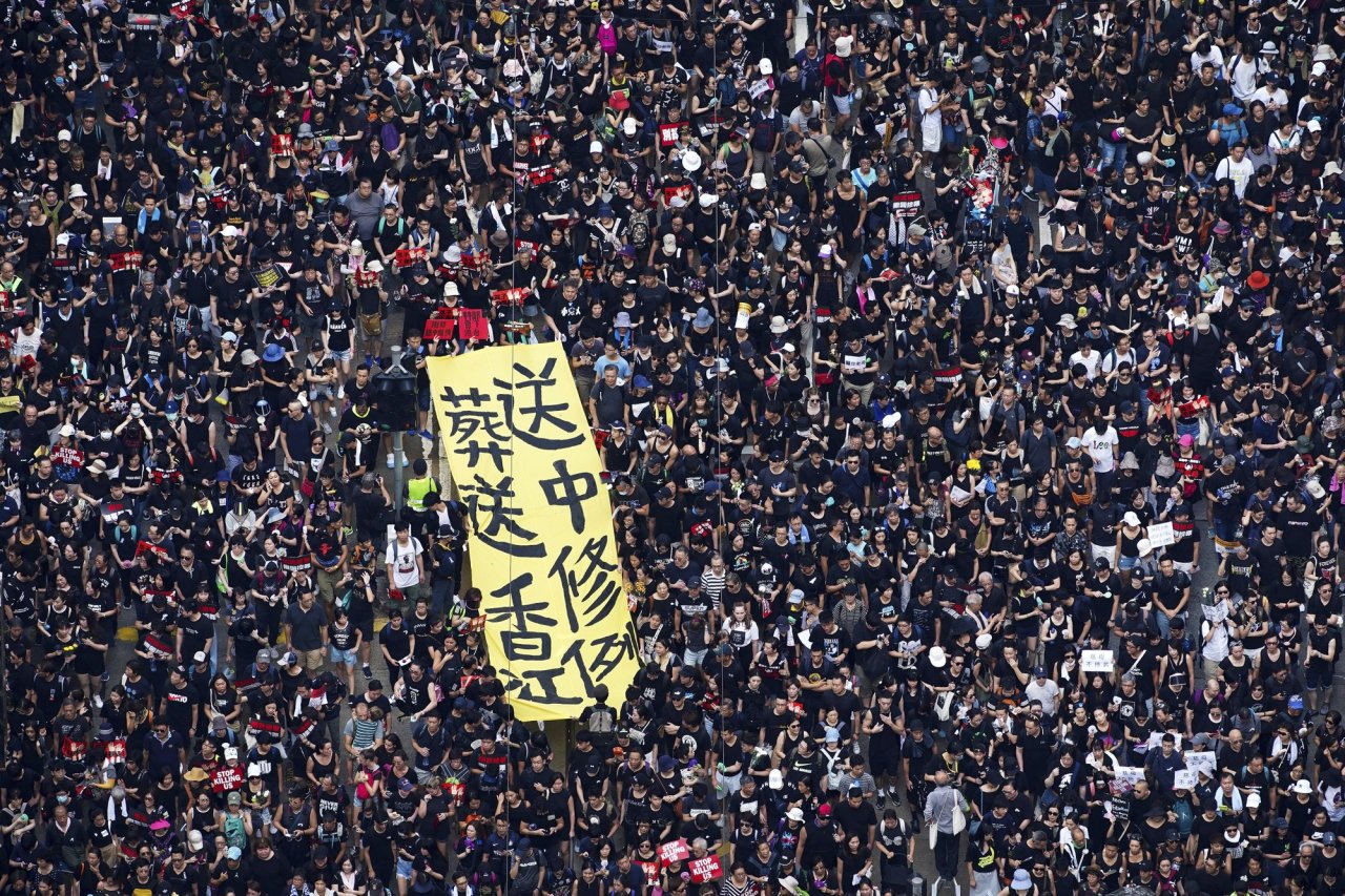 Tens of thousands of protesters carry posters and banners march through the streets as they continue to protest an extradition bill, Sunday, June 16, 2019, in Hong Kong. Hong Kong residents Sunday continued their massive protest over an unpopular extradition bill that has highlighted the territory`s apprehension about relations with mainland China, a week after the crisis brought as many as 1 million into the streets. The yellow banner reads "Extradition law, funeral to Hong Kong". (AP)