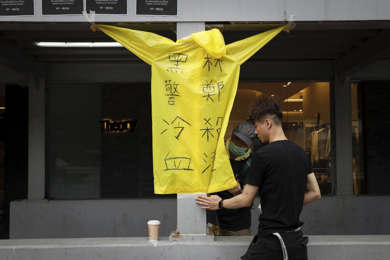 Protesters place a raincoat bearing the words "Cold blooded black police, Carrie Lam kill Hong Kong" on the site where a man fell to his death a day earlier after hanging a protest banner on the scaffolding of a shopping mall in Hong Kong, Sunday, June 16, 2019. (AP)