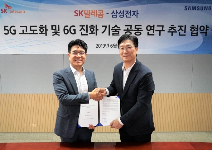 Jeon Jae-ho (R), head of network business R&D at Samsung Electronics Co., and Park Jin-hyo, the CEO of SK Telecom Co. (SKT)