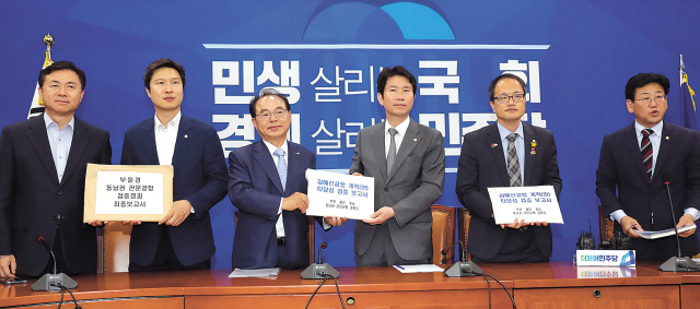 오거돈 부산광역시장이 지난달 27일 오후 국회 원내대표실에서 열린 부울경 동남권 관문공항 검증결과 대국민보고대회 사전 간담회 및 보고서 전달식에서 더불어민주당 이인영 원내대표 등 당 지도부에게 김해신공항 계획안 타당성 검증 보고서를 전달하고 있다. 왼쪽부터 김영춘 의원, 김해영 최고위원, 오거돈 시장, 이인영 원내대표, 박주민 최고위원, 김정호 의원.    [연합]