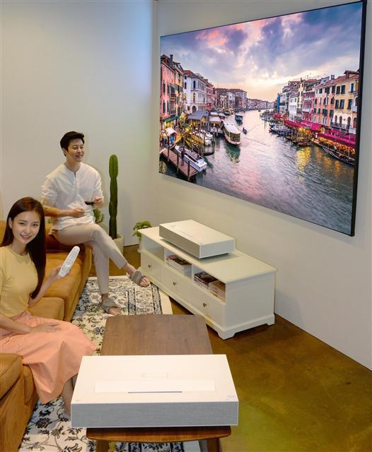 LG전자가 초고화질ㆍ초대형 화면에 편의성까지 갖춘 ‘LG 시네빔 Laser 4K’ 프로젝터(모델명 HU85LA)를 다음달 1일 국내 시장에 출시한다. ‘LG 시네빔 Laser 4K’은 4K UHD(3840X2160) 해상도와 2,000,000:1의 명암비를 지원한다. 화면 밝기는 최대 2700 안시루멘으로, 촛불 2700개를 동시에 켠 밝기 수준이다.  밝은 환경에서도 또렷하고 생생한 화질을 보여주는 것이 특징이다. 또 초단초점 기술을 탑재해 좁은 공간에서 초대형 화면을 구현한다. 제품과 스크린 사이가 10㎝만 돼도 100인치의 대화면을 보여준다.   [LG전자 제공]