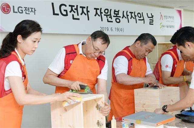 LG전자 조성진 부회장(왼쪽 두번째)이 LG전자 임직원들과 함께 재활원에 전달할 가구를 만들고 있다. [LG전자 제공]