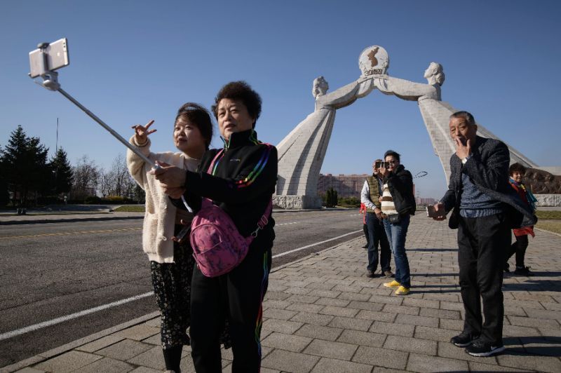 Tourists from China pose for photos before the Three Charters monument in the North Korean capital Pyongyang (AFP-Yonhap)