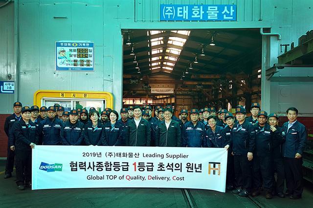 두산인프라코어의 협력사 육성 프로그램에 참여한 협력사 5곳 가운데 하나인 태화물산에서 관계자들이 기념촬영을 하고 있다.