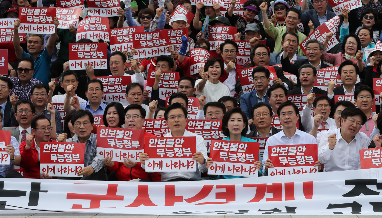 Main opposition Liberty Korea Party lawmakers and officials, including Chairman Hwang Kyo-ahn (fourth from right) and floor leader Rep. Na Kyung-won, hold a rally in Seoul on Sunday. Yonhap