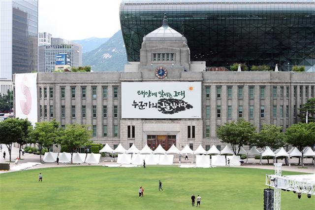27일 오전 여름을 맞아 새 옷으로 갈아입은 서울도서관 외벽 꿈새김판앞을 시민들이 지나고 있다.
