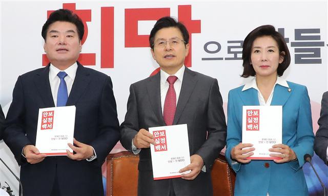 황교안 자유한국당 대표(가운데)와 나경원 원내대표(오른쪽), 원유철 의원이 28일 오전 국회에서 열린 북핵외교안보특위에서 ‘안보실정백서’를 들어 보이고 있다.   [연합]