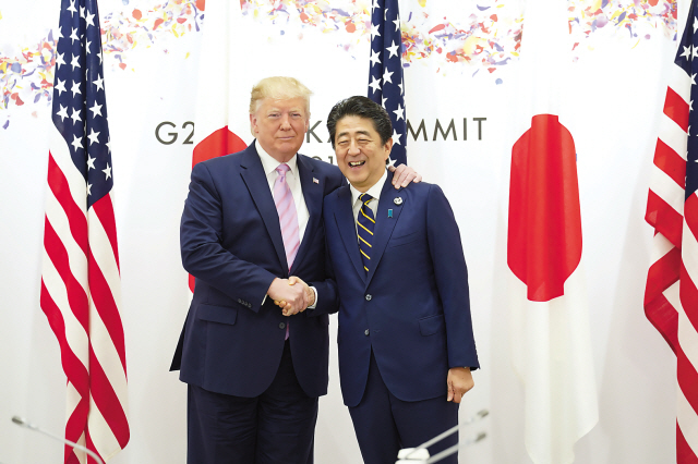 도널드 트럼프 미국 대통령(왼쪽)과 아베 신조 일본 총리가 주요 20개국(G20) 정상회의 개막일인 28일 오전 회의장소인일본 오사카 오사카인덱스에서 만나 악수를 하고 있다.  [로이터]