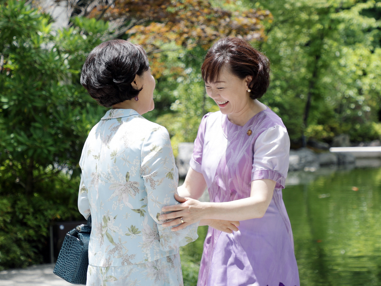 문재인 대통령 부인 김정숙 여사와 아베 신조 G20 의장국인 일본 아베 신조 총리 부인 아베 아키에 여사가 28일 오전(현지시간) 가든 오리엔탈 오사카에서 열린 G20 정상 배우자 환영 차담회에서 만나 인사하고 있다. [연합]