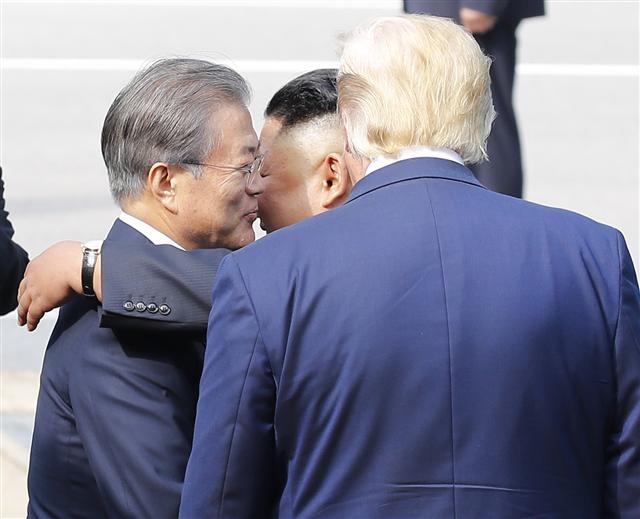 김정은 북한 국무위원장이 30일 판문점 남측 자유의 집에서 도널드 트럼프 미국 대통령과 회동을 마친 뒤 군사분계선에서 문재인 대통령과 트럼프 대통령의 배웅을 받고 있다.  [연합]