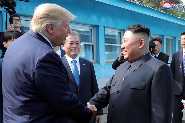 도널드 트럼프 미국 대통령과 김정은 북한 국무위원장이 30일 오후 판문점에서 악수하고 있는 가운데 문재인 대통령이 이를 바라보고 있다. 트럼프의 ‘트윗 제안’으로 성사된 이날의 남북미 판문점 회동은 ‘세기의 회동’으로 불릴만큼 상징적인 장면과 기록을 남겼다.   [연합]