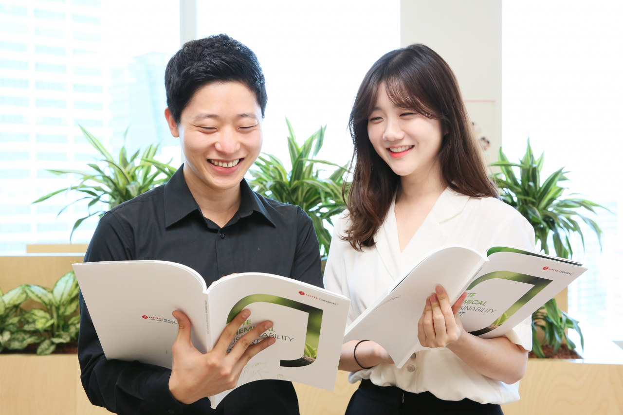 롯데케미칼 직원들이 지속가능경영보고서를 보고 있다. [롯데케미칼 제공]