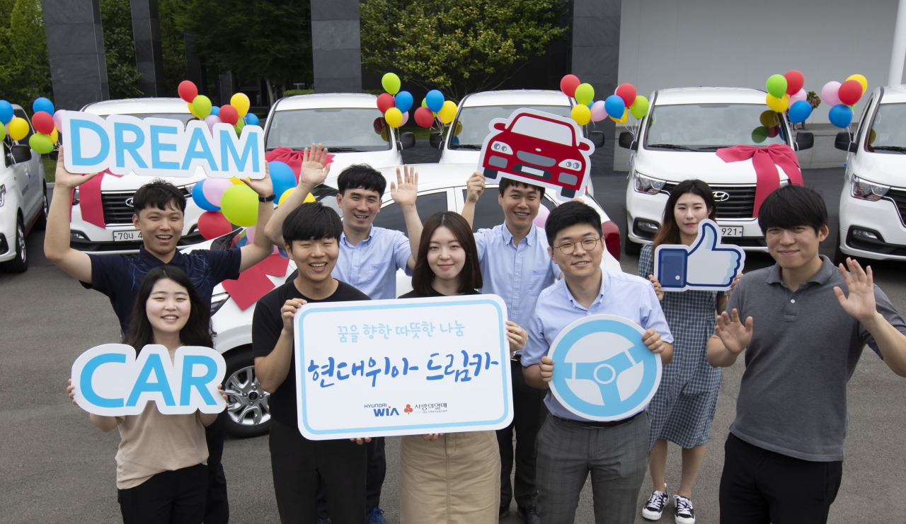 현대위아 임직원들이 4일 경상남도 창원시 성산구 현대위아 본사에서 열린 ‘2019년 상반기 드림카 전달식’에서 선물할 차량과 함께 기념사진을 찍고 있다. [현대위아 제공]