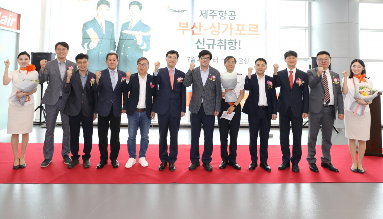 4일 오후 김해국제공항에서 진행된 제주항공 부산~싱가포르 노선 신규취항식에 참석한 신규 취항편 승무원들과 내·외빈들이 기념촬영을 하고 있다. 왼쪽에서 두 번째부터 조영근 김해국제공항경찰대 안전3계장, 김용진 김해국제공항 출입국·외국인사무소 입국과장, 박청하 한국공항공사 부산지역본부 운영단장, 나호주 부산관광공사 상임이사, 이석주 제주항공 대표이사, 송광행 부산광역시 신공항추진본부장, 박준희 김해국제공항세관 휴대품과장, 이철행 제주항공 대외협력본부장, 좌승민 제주항공 부산지점장. [제주항공 제공]