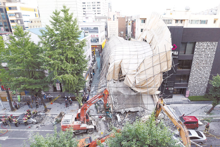 지난 4일 오후 2시23분께 서울 서초구 잠원동에서 철거작업 중인 건물이 붕괴해 지지대와 인근 전신주 등이 차도를 덮쳤다. 사진은 붕괴 현장으로 출동한 119구조대원 등이 포크레인과 구조장비를 동원해 구조작업을 벌이고 있는 모습.  [연합]