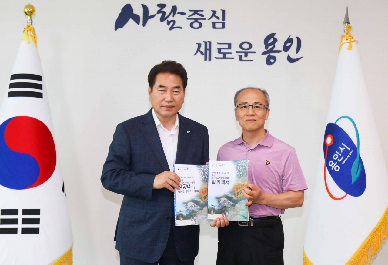 백군기 용인시장(왼쪽)이 유형별 난개발 실태 담은 백서를 전달받았다.[용인시 제공]