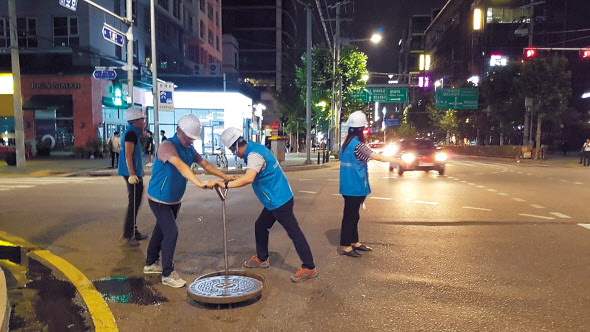 지난 6일 밤 10시 영등포구 문래동 현대3차 아파트 앞에서 현장모와 안전조끼를 착용한 서울시 상수도사업본부 현장 직원들이 소화전 퇴수작업을 하고 있다(왼쪽). 문래동 ‘붉은 수돗물’ 관세척 작업. 소화전을 이용해 수돗물을 하수로로 배출시키고 있다.  [서울시 제공]