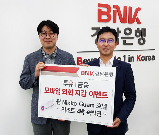 BNK경남은행 창원시청지점 임재문 영업점장(사진 오른쪽)이 모바일 외화 지갑 서비스 출시 기념 이벤트 1등 당첨자에게 ‘괌 닛코 호텔 4박 숙박권 증서’를 전달하고 있다.