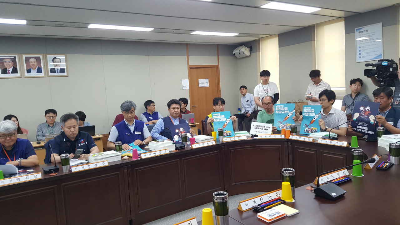 10일 정부세종총사에서 열린 최저임금위원회 11차 전원회의에 참석한 노동계를 대표하는 일부 노동자위원들이 경영계의 최저임금 삭감안을 규탄하는 피켓을 들어 보이고 있다. [헤럴드DB]