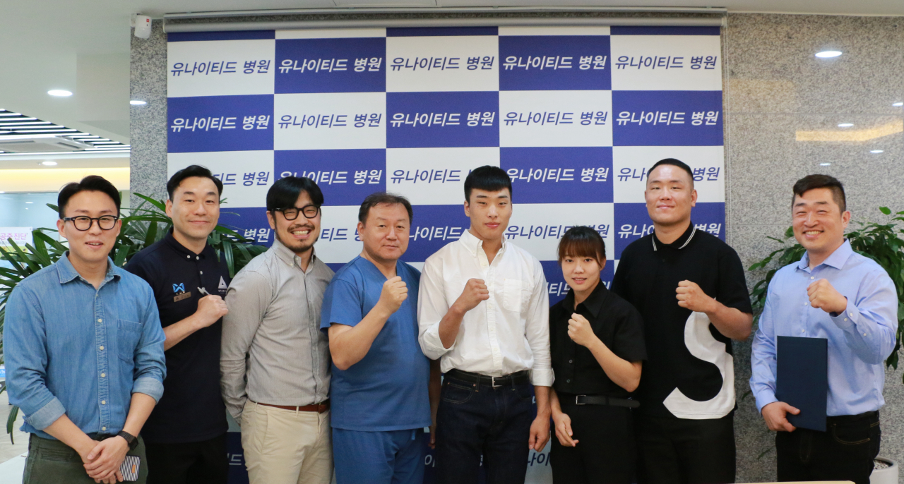 UFC 파이터 최승우가 유나이티드병원 김현철 원장과 의료지원 협약식을 맺고 관계자들과 함께 기념촬영에 응하고 있다 [TNS 제공]