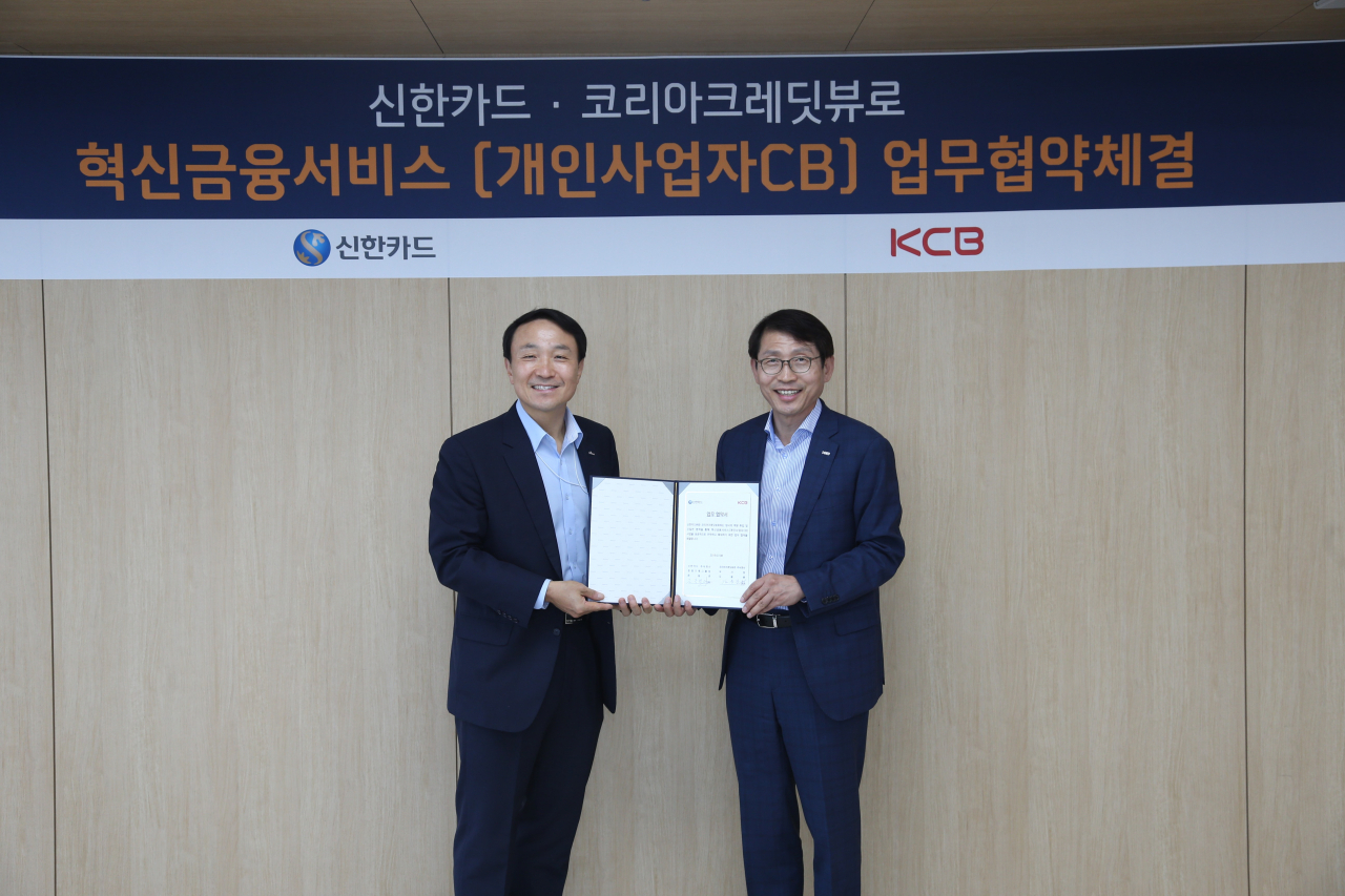 문동권(왼쪽) 신한카드 경영기획그룹장과 김용봉 KCB 부사장이 지난 15일 서울 을지로 신한카드 본사에서 신용평가 사업 협업을 위한 전략적 제휴 협약식을 가진 뒤 기념 사진을 찍고 있다. (제공=신한카드)
